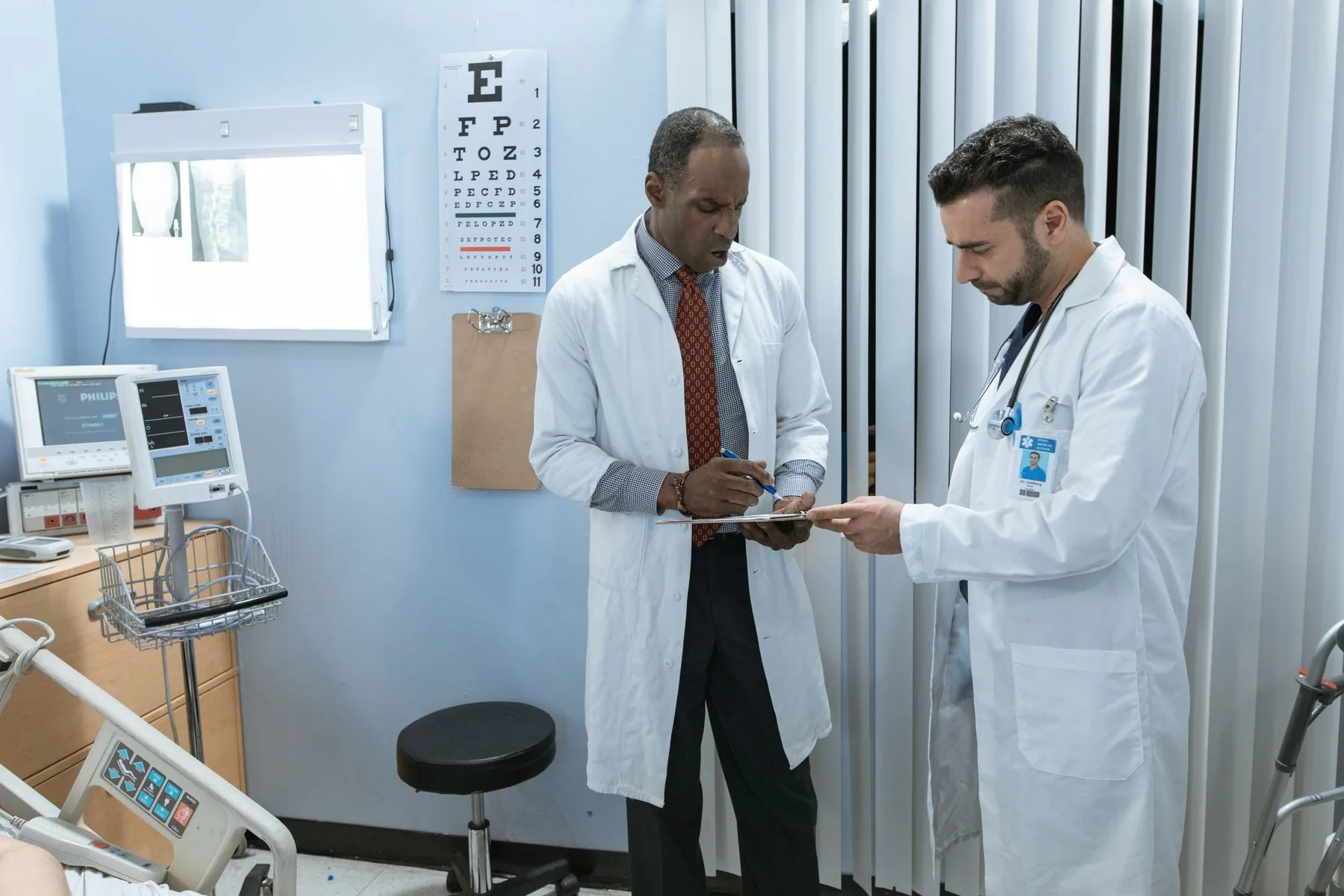 Two clinicians reviewing patient notes together in an examination room