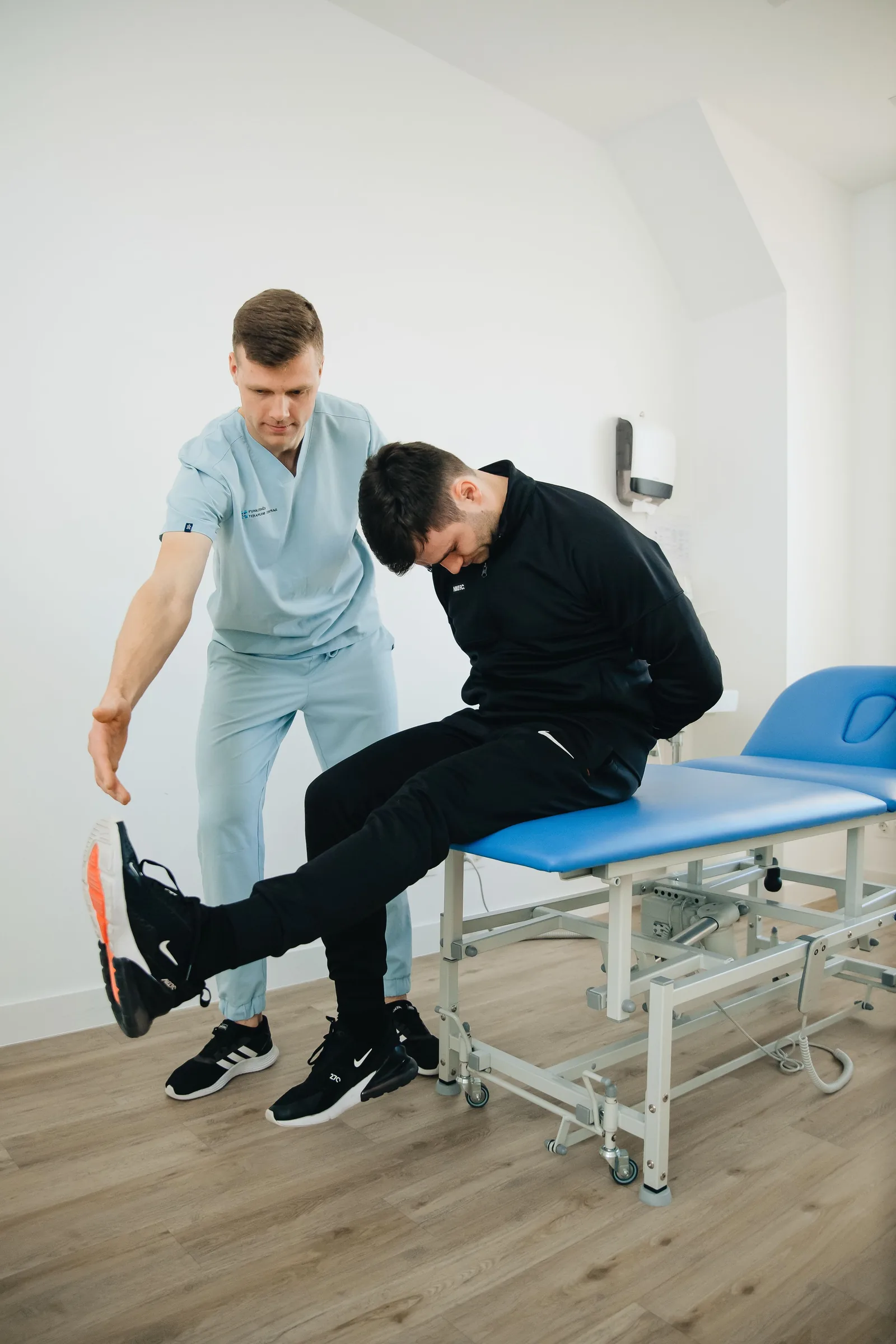 A physiotherapist guiding a patient through a leg-strengthening exercise