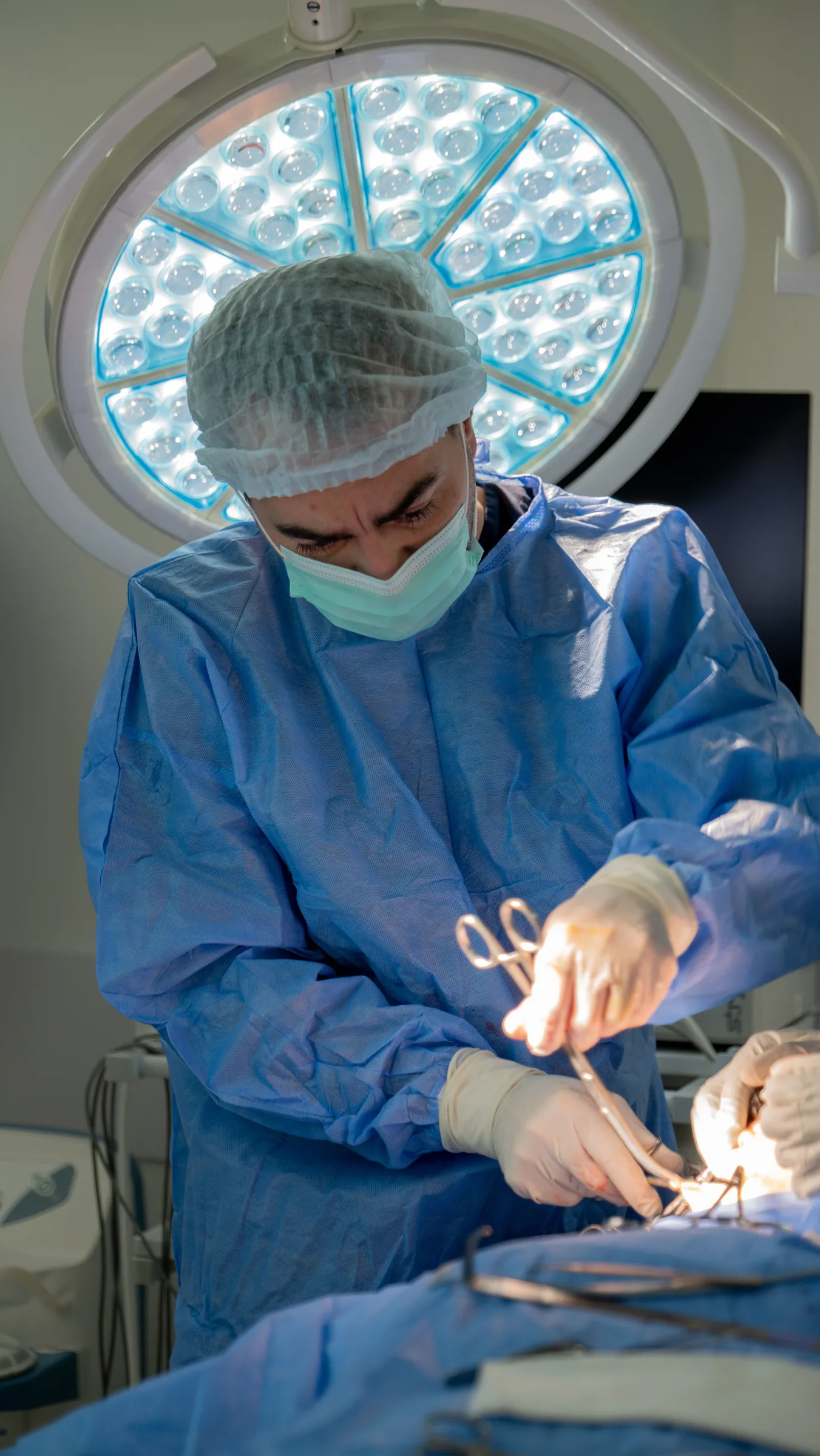 A surgeon operating under theatre lights